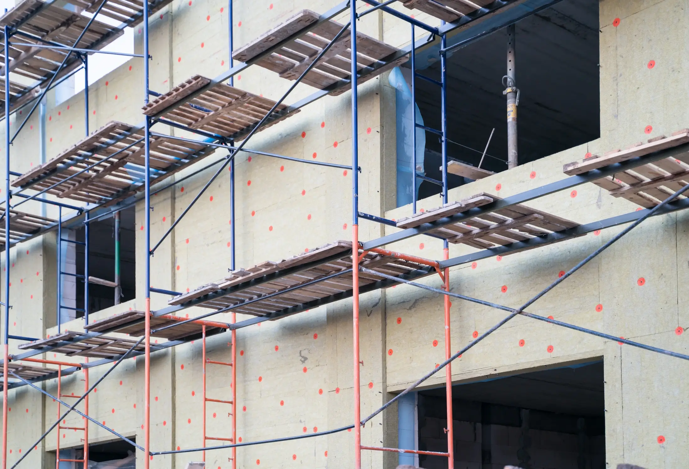 Fassadenbau im Neubau mit Gerüst vor unverputzter Außenwand
